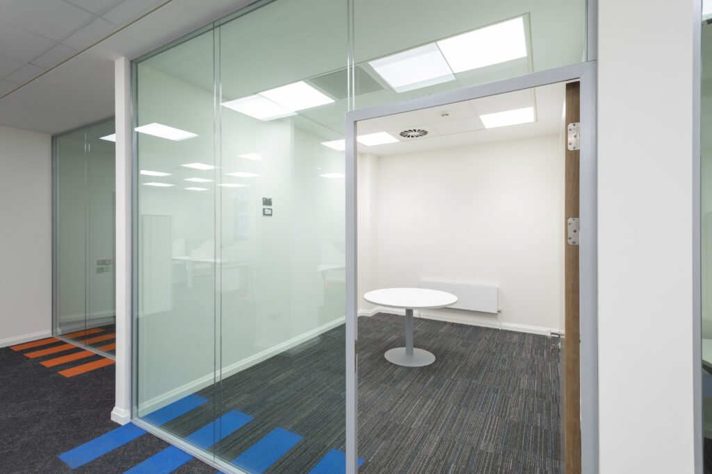 This project involved the renovation of the ground floor from open plan meeting spaces to an open plan office. It includes a number of private spaces and a large boardroom that is divided with a combination of acoustic and glazed partitions. In order to extend the open plan area, we filled in the existing stairwell to a basement with concrete. Originally, there was a commercial kitchen toilet changing room and store in the basement. We demolished all partitions and removed all floor and wall partitions. We then refitted new partitions. This included a canteen, two meeting rooms, male/female toilets, shower and changing rooms, store area, new ducting for heat recovery units, and passive fire duct fitted for the lobby area.  We also completed all floor and wall finishes. Externally, we removed the façade and installed a new one. Following this, we fitted an entrance to suit the new ground floor layout. We also fitted a new emergency door leading to a laneway and removed and replaced an old bar door with a new window to match.